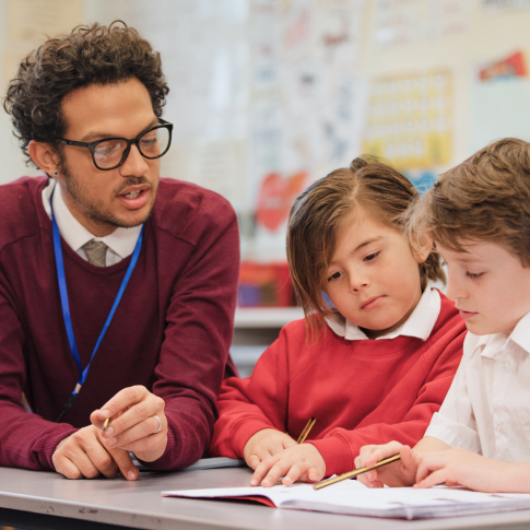 teacher and two children studying at The Schenk School